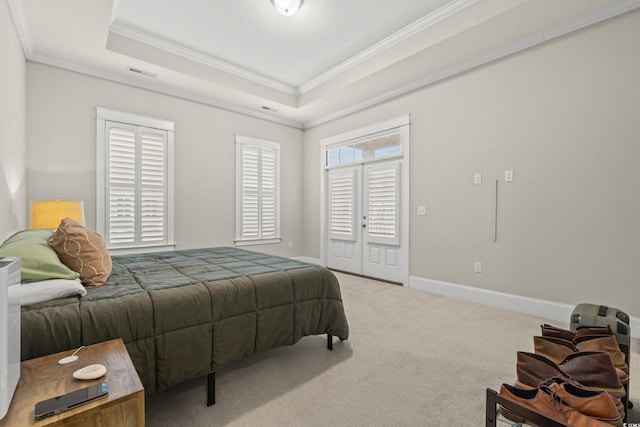 carpeted bedroom featuring a tray ceiling, baseboards, visible vents, and ornamental molding