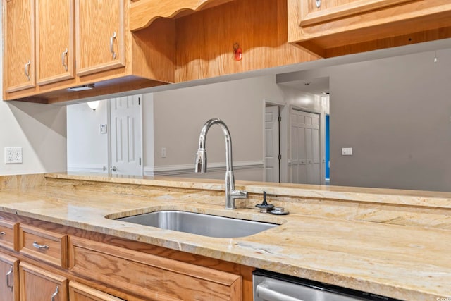 kitchen featuring a sink, light stone countertops, and stainless steel dishwasher