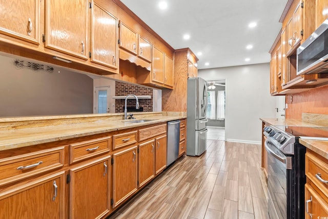 kitchen with a ceiling fan, a sink, recessed lighting, light wood-style floors, and appliances with stainless steel finishes