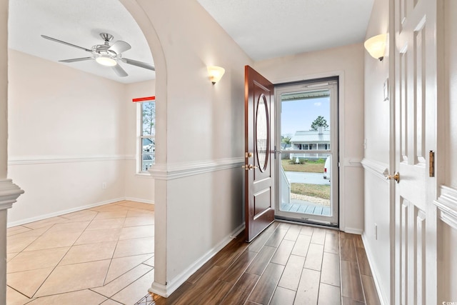 foyer featuring wood finished floors, baseboards, and ceiling fan