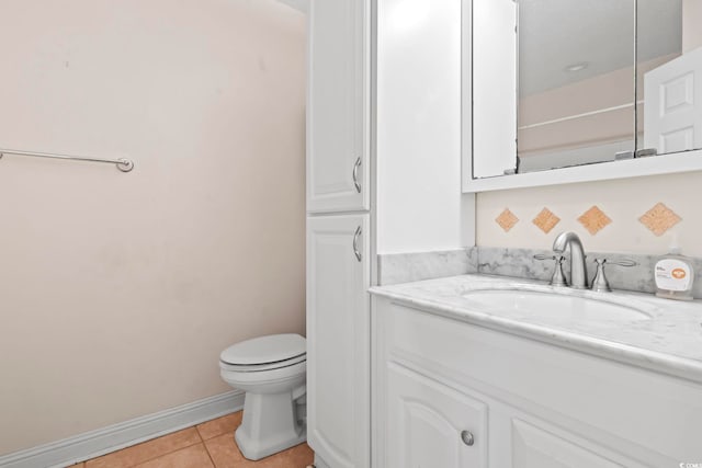 bathroom with tile patterned flooring, toilet, vanity, and baseboards