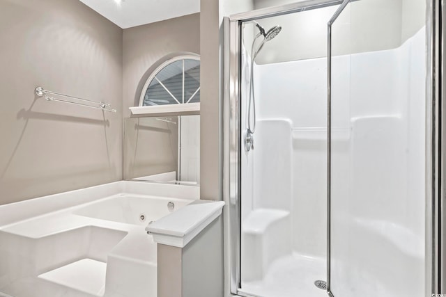 bathroom featuring a tub with jets and a shower stall