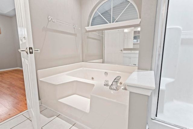 full bathroom with tile patterned flooring, a whirlpool tub, and walk in shower