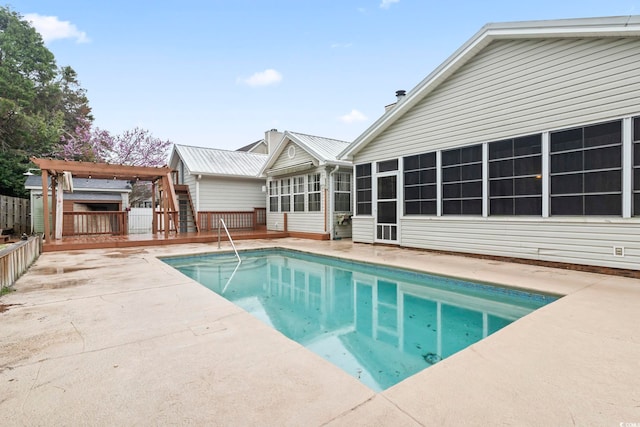 view of swimming pool featuring a fenced in pool, a wooden deck, a pergola, a sunroom, and a patio area