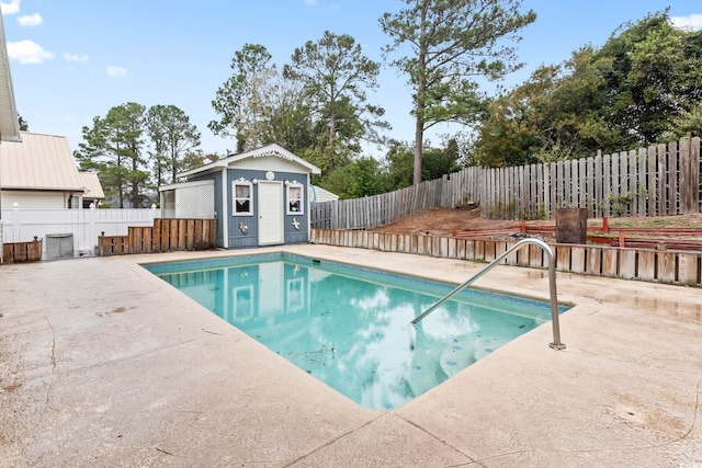 view of swimming pool with a fenced in pool, a patio, an outbuilding, and a fenced backyard