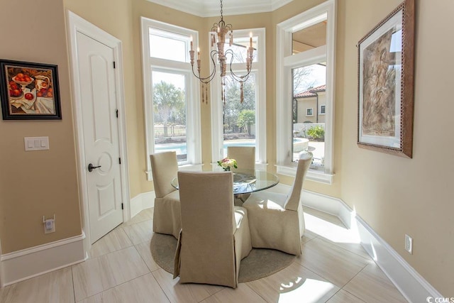 dining room with a chandelier, baseboards, and ornamental molding