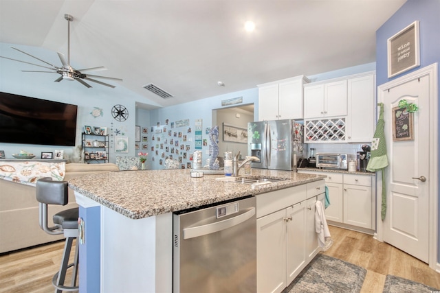 kitchen with light wood-style flooring, white cabinets, visible vents, and appliances with stainless steel finishes