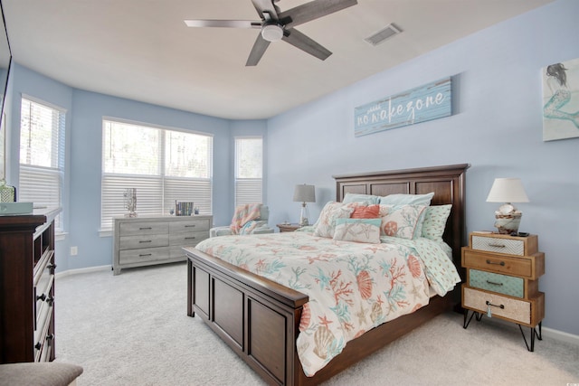 bedroom with a ceiling fan, light colored carpet, visible vents, and baseboards