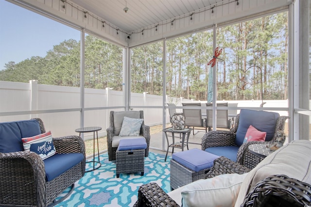 sunroom / solarium featuring rail lighting