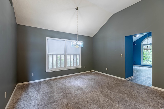 empty room with vaulted ceiling, a notable chandelier, carpet flooring, and baseboards