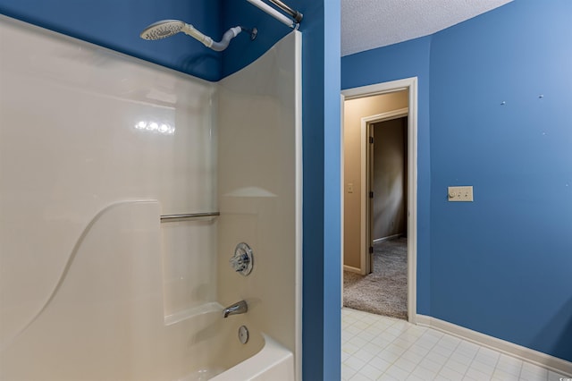 bathroom with a textured ceiling, tile patterned floors, baseboards, and shower / bath combination