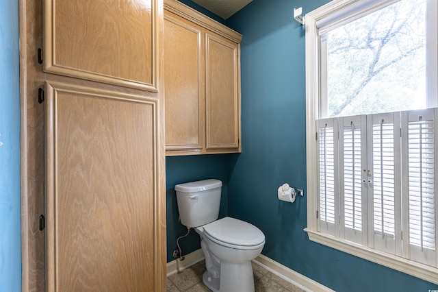 bathroom with toilet and baseboards