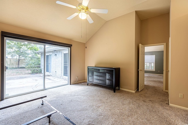 carpeted empty room featuring plenty of natural light, high vaulted ceiling, baseboards, and a ceiling fan