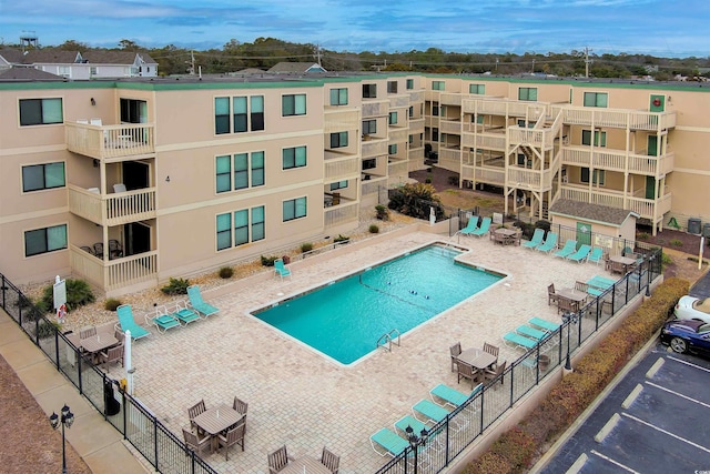 community pool featuring a patio and fence