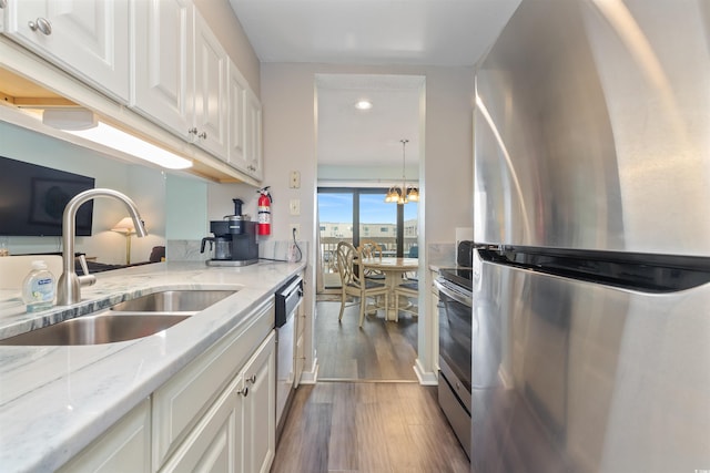 9661 Shore Dr Unit A-21, Myrtle Beach, SC 29572 - kitchen featuring stainless steel appliances, a sink, white cabinetry, dark wood-style flooring, and light stone countertops