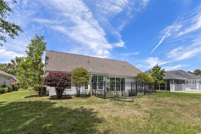 back of house with a lawn and fence