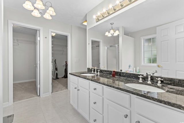 bathroom with a chandelier, tile patterned flooring, double vanity, and a sink