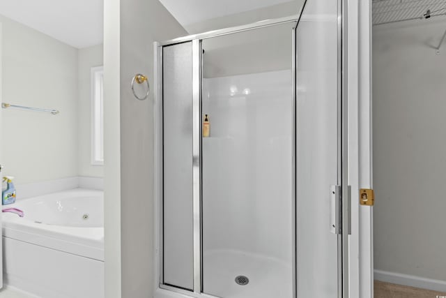 bathroom featuring a jetted tub and a stall shower