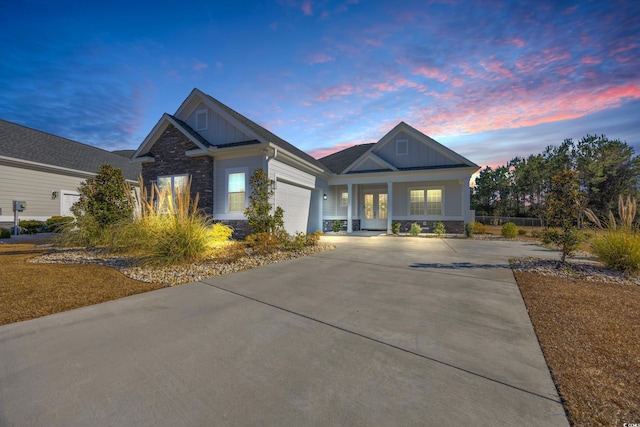 craftsman house featuring stone siding, board and batten siding, concrete driveway, and an attached garage