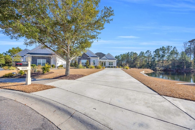 view of front of house with a water view and driveway