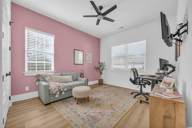 office featuring a wealth of natural light, baseboards, wood finished floors, and ceiling fan