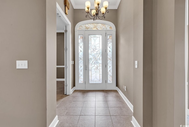 foyer featuring crown molding, a chandelier, baseboards, and light tile patterned floors