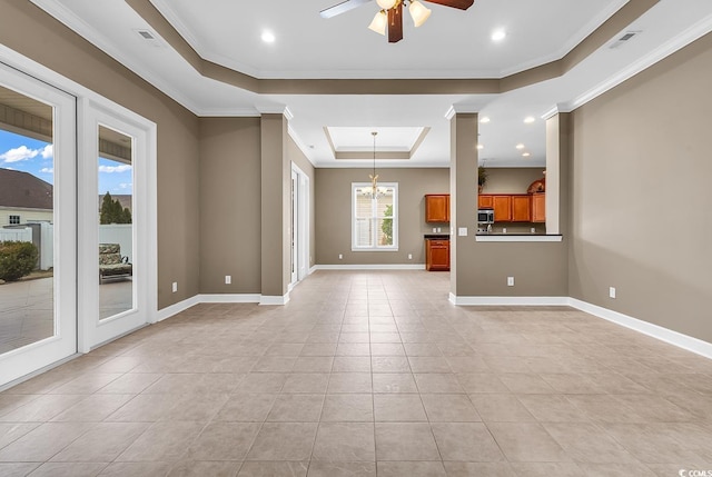 unfurnished living room with a tray ceiling, a ceiling fan, light tile patterned flooring, crown molding, and baseboards