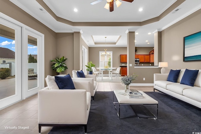 living room with a tray ceiling, light tile patterned floors, ceiling fan, crown molding, and recessed lighting