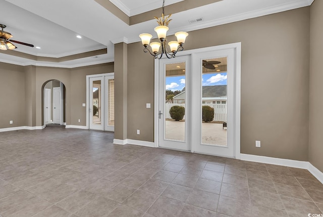 spare room featuring a tray ceiling, ornamental molding, arched walkways, ceiling fan, and a chandelier