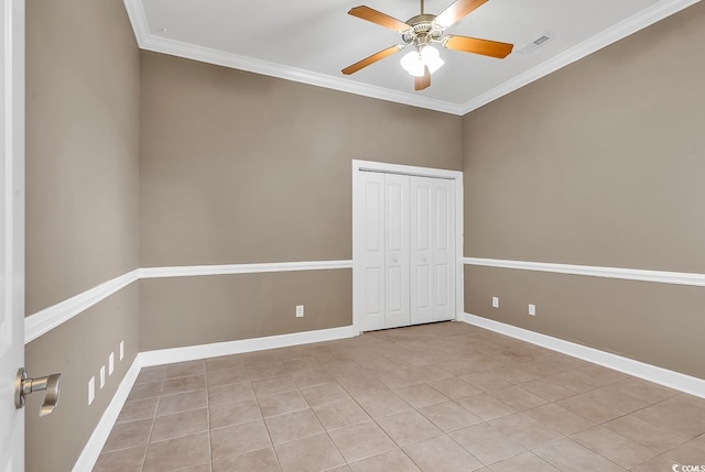 empty room featuring visible vents, ornamental molding, a ceiling fan, light tile patterned floors, and baseboards