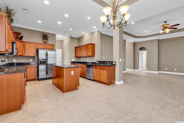 kitchen with a kitchen island, ornamental molding, brown cabinets, appliances with stainless steel finishes, and arched walkways