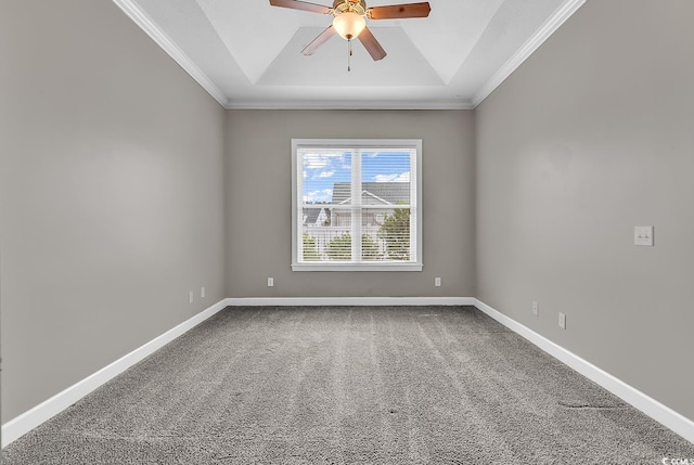 carpeted spare room featuring ornamental molding, a tray ceiling, a ceiling fan, and baseboards
