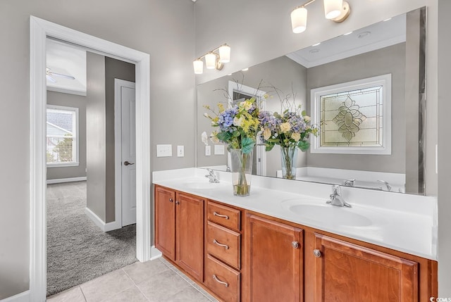 bathroom with tile patterned floors, double vanity, baseboards, and crown molding