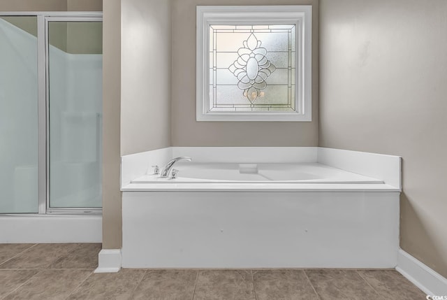 full bathroom with a shower stall, a garden tub, tile patterned flooring, and baseboards