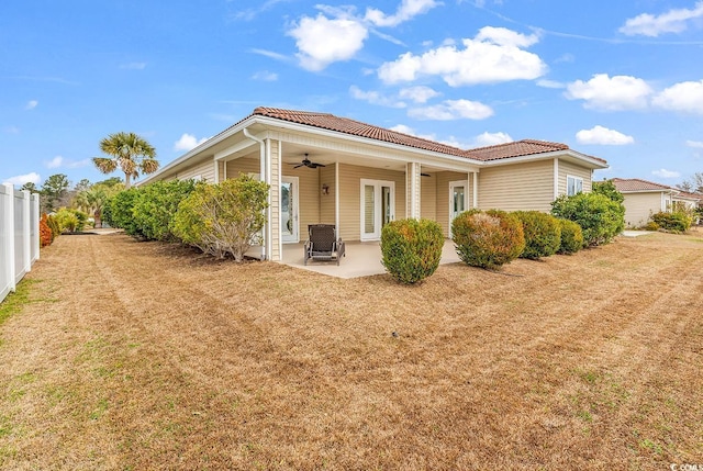 back of house featuring a tile roof, ceiling fan, and a patio