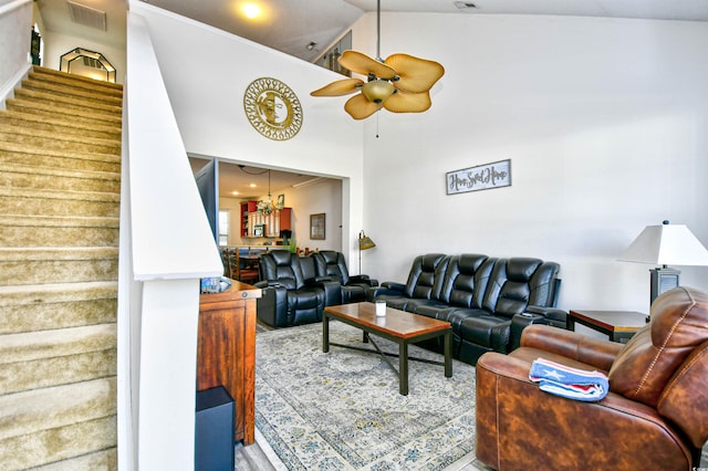 living area featuring visible vents, high vaulted ceiling, ceiling fan, and stairs