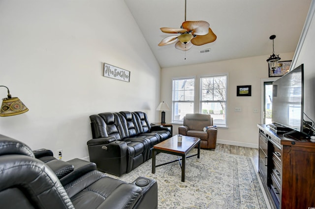 living room featuring baseboards, visible vents, light wood-style flooring, ceiling fan, and vaulted ceiling