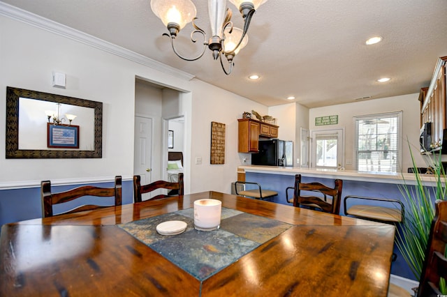 dining space with recessed lighting, a textured ceiling, and a chandelier