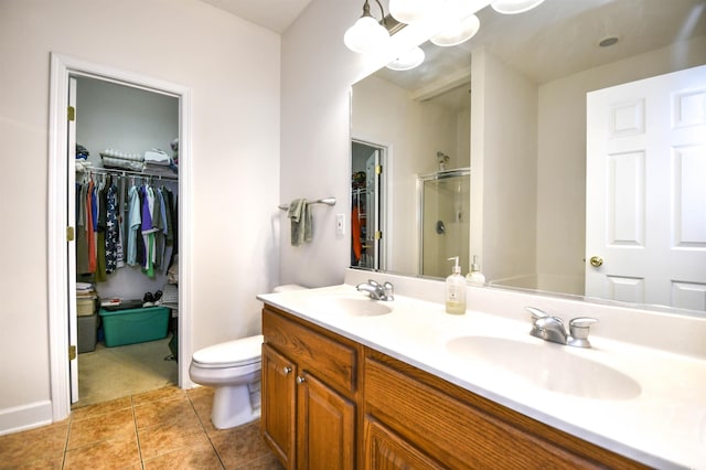 bathroom featuring tile patterned flooring, a shower stall, a walk in closet, and a sink