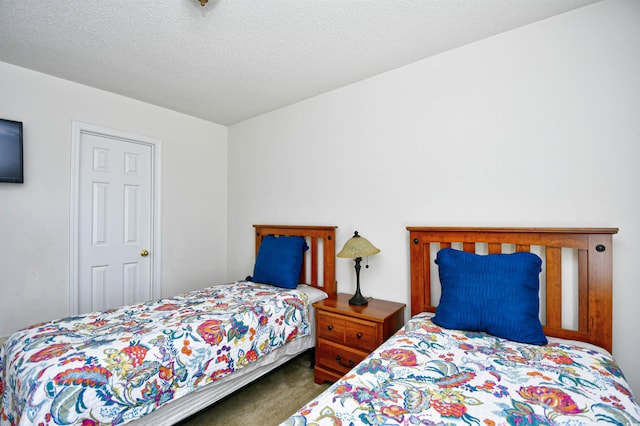 carpeted bedroom featuring a textured ceiling