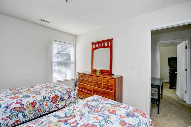 carpeted bedroom with visible vents and a textured ceiling