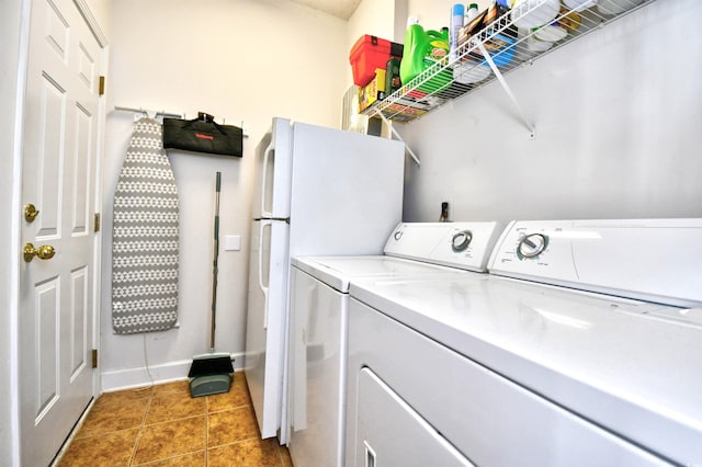 laundry room with washer and dryer, baseboards, tile patterned floors, and laundry area