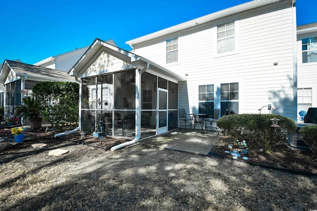 rear view of property featuring a patio and a sunroom