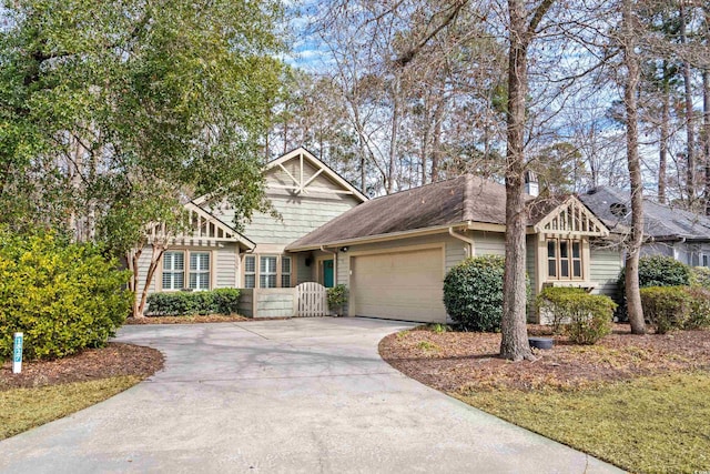 view of front of home with concrete driveway, a garage, and a shingled roof