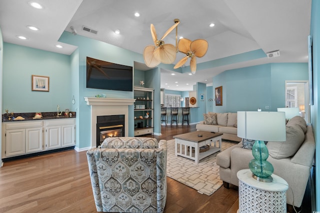 living room featuring recessed lighting, visible vents, and wood finished floors