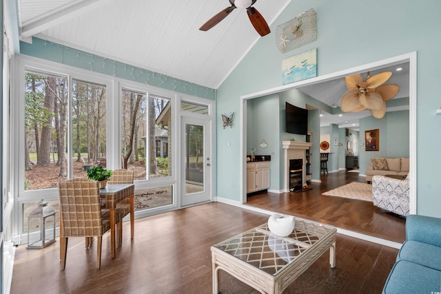 sunroom / solarium with lofted ceiling, plenty of natural light, a fireplace, and ceiling fan