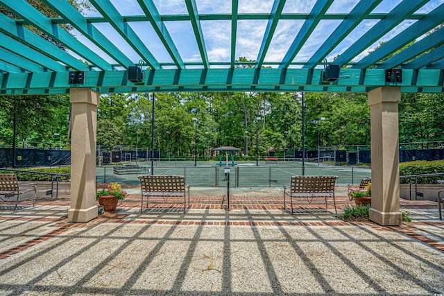 exterior space featuring fence, a tennis court, and a pergola