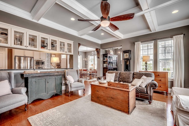 living room featuring beamed ceiling, light wood-type flooring, recessed lighting, ceiling fan with notable chandelier, and coffered ceiling