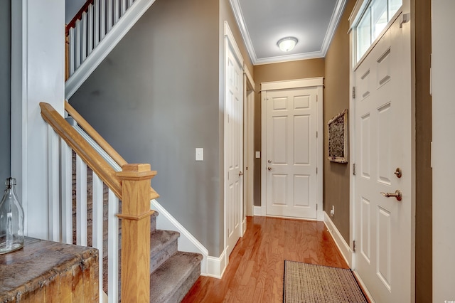 interior space with baseboards, stairs, light wood-style floors, and ornamental molding