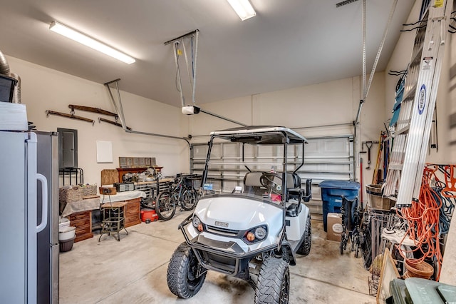 garage featuring electric panel and freestanding refrigerator